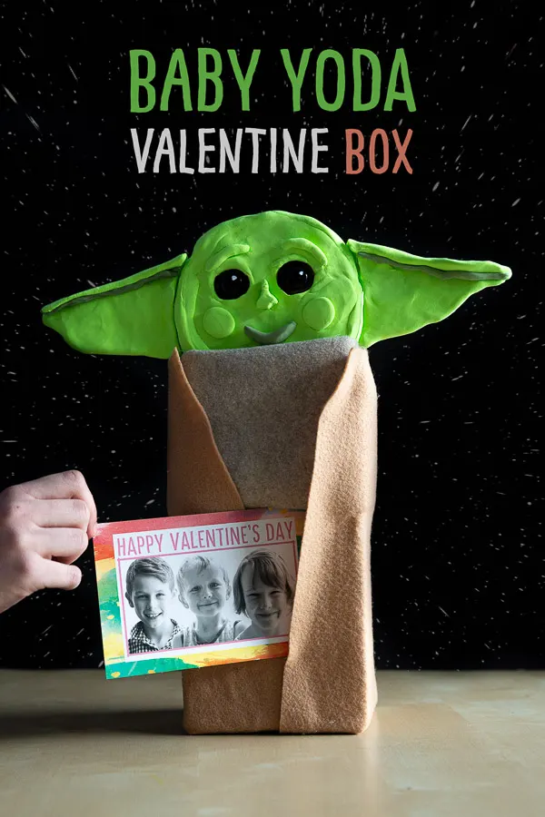 Baby Yoda Valentine's Day Box: Transform an old tissue box into this cute baby Yoda to hold your Valentine's Day cards! We show this recycled Valentine's day craft for kids which is sure to make classmates smile. With a kleenex box, some felt, buttons, a cheese wheel and model magic, you too can create your own baby Yoda project to hold your Valentines.